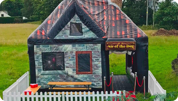 Air of the Dog inflatable pub with picnic bench seating and white picket fencing