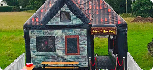 Air of the Dog inflatable pub with bench seating and white picket fencing